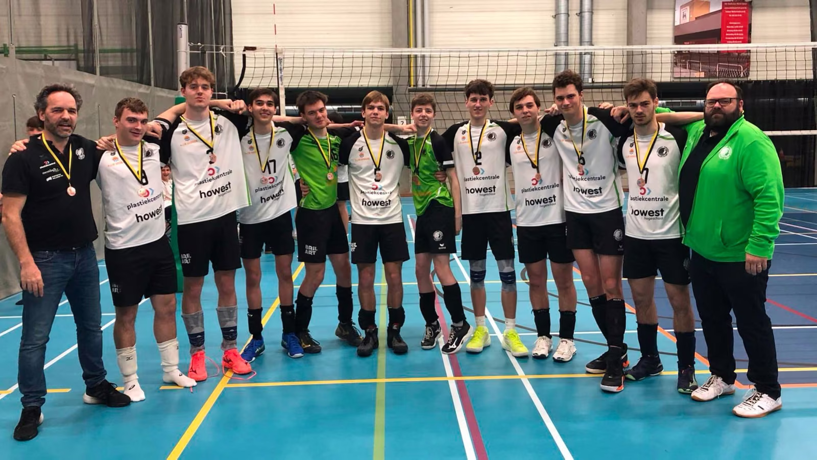 De U19 van Rembert staat op een rij in de sporthal met hun bronzen medailles uit de Champions League, met twee coaches.