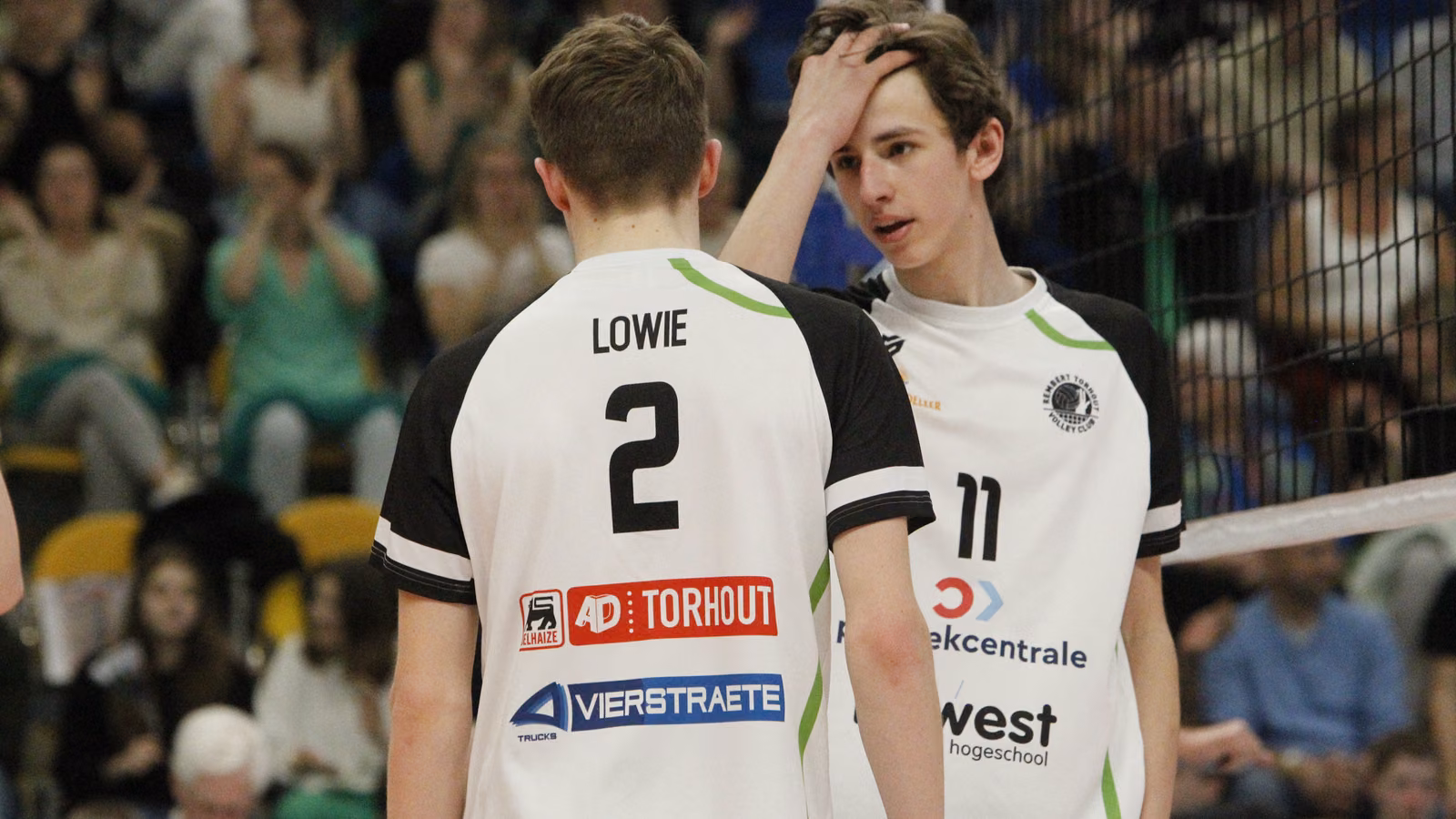 Twee jeugdspelers van Rembert op het veld tijdens de Vlaamse kampioenschappen, voor een volle tribune.