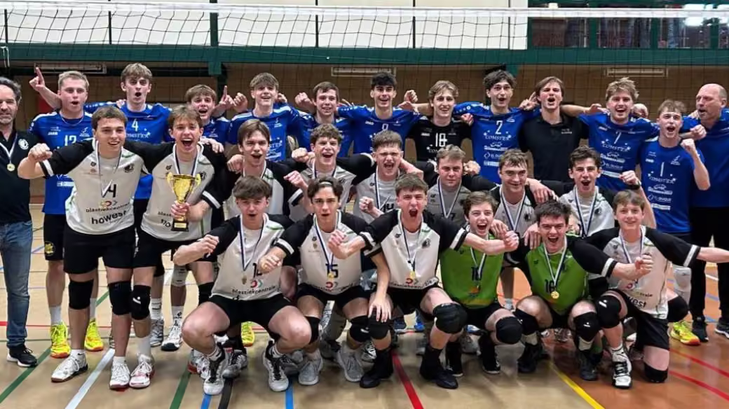 De U19 van Rembert juicht met de beker en medailles als Champions League-winnaar, samen met de tegenstander en de coaches.